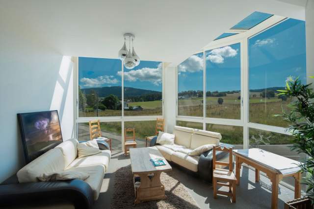 vue panoramique depuis l'intérieur sur prairie et montagne, petit salon